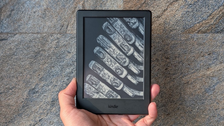 A Kindle e-reader in hand.