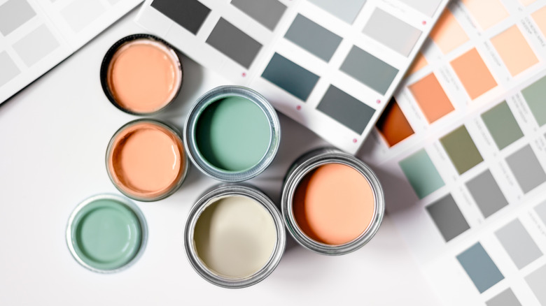 Collection of colored paints in cans and paint sample cards