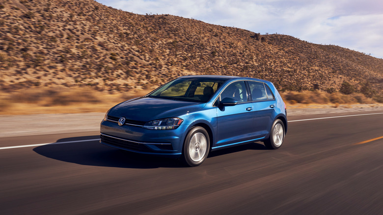 A frontal 3/4 of a blue 2021 Volkswagen Golf driving