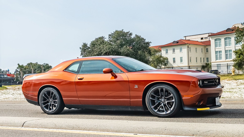 An orange Dodge Challenger R/T parked on a road.