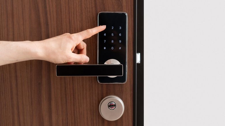 typing code into smart door lock