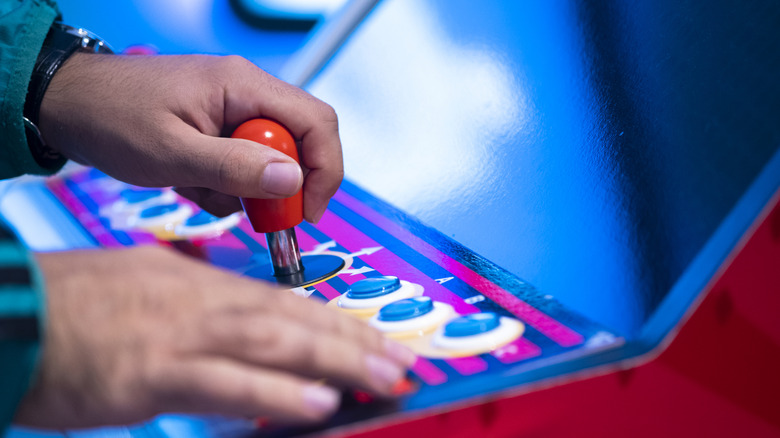 Close-up of a person playing with an arcade machine