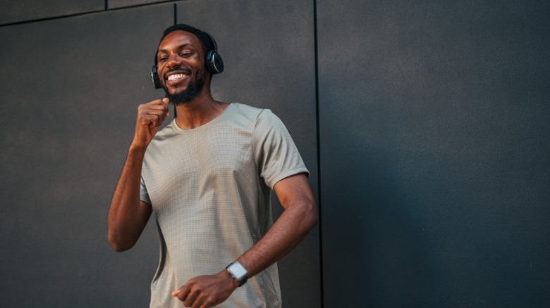 A young man wearing headphones and a smart watch