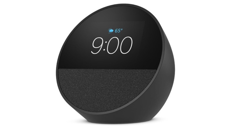 A black Amazon Echo Spot with the display on,
