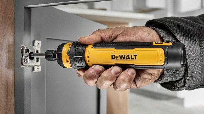 A DeWalt electric screwdriver being used on a door
