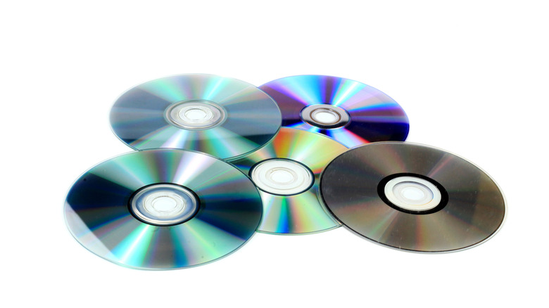 Arrangement of five compact discs on white background