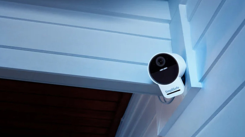 SimpliSafe home security camera mounted outside home at dusk