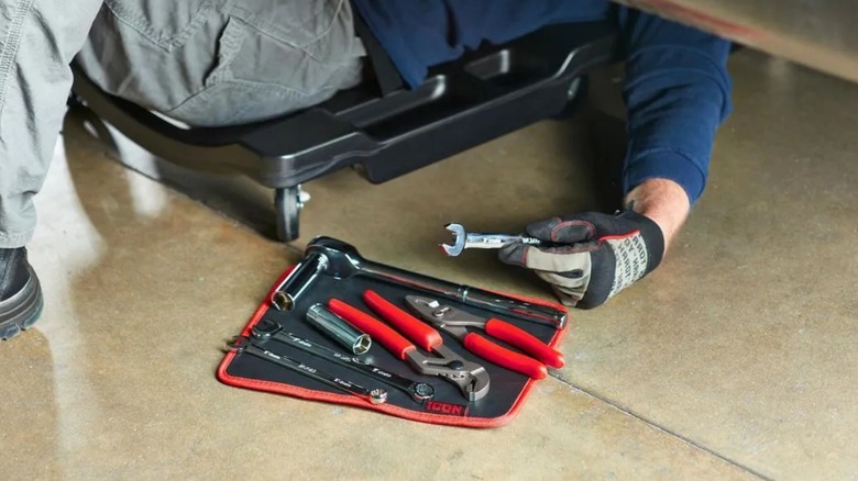 Mechanic taking tool from an Icon magnetic tool mat