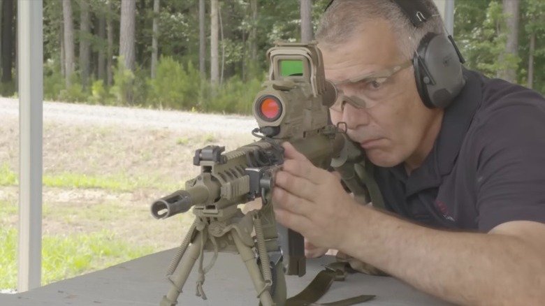 A man firing a rifle with a smart scope