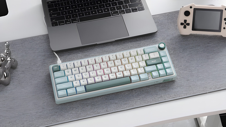 royal kludge r65 keyboard on desk with laptop and gaming handheld