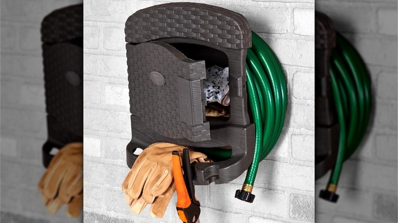 Lakeside Collection Garden Water Hose Reel Hanger with hose, gloves, and shears on brick wall