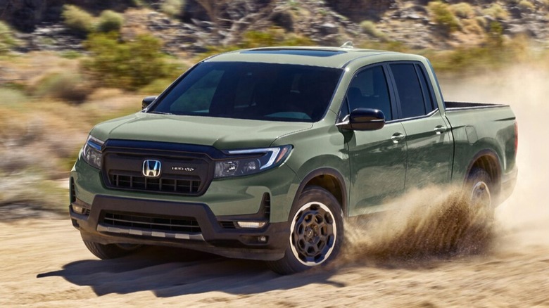 A 2026 green Honda Ridgeline pickup charges across a dusty desert trail, blending rugged power with everyday comfort.