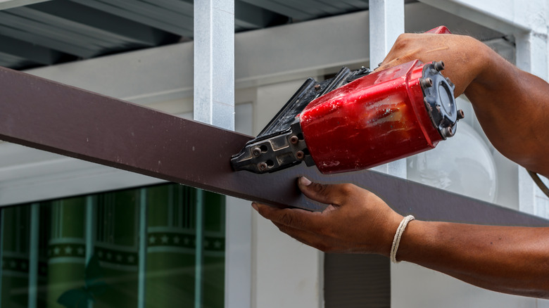a person using a Milwaukee nail gun