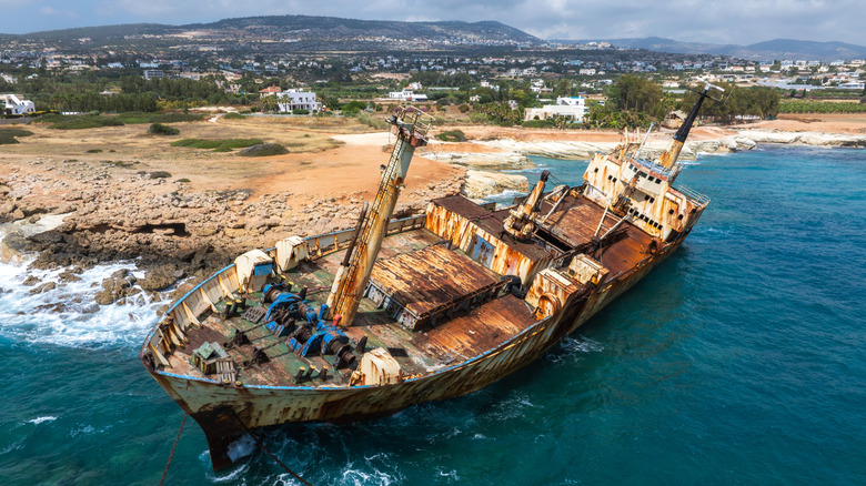 Shipwreck tilted at an angle along the beach shore