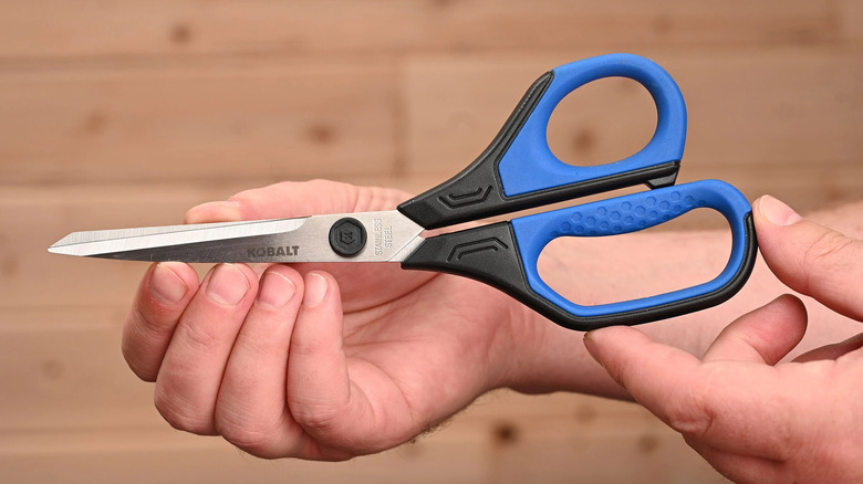 Hands holding Kobalt scissors