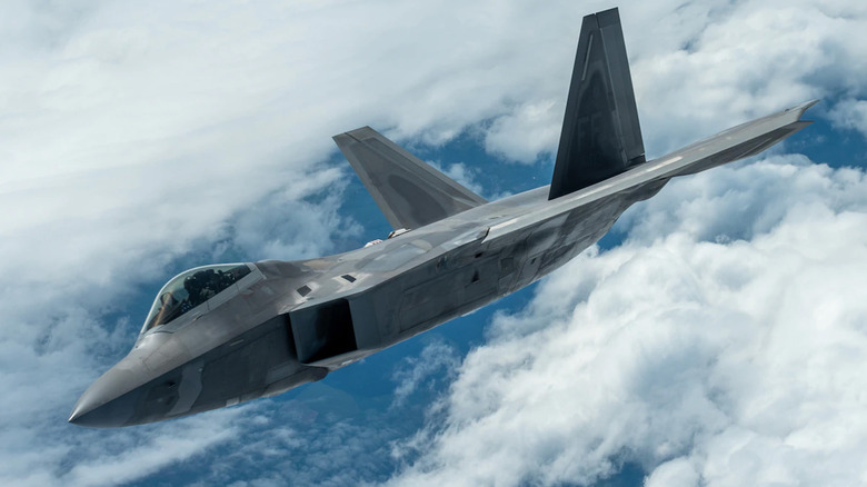 An F-22 Raptor mid-flight among the clouds