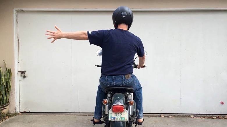 motorcycle rider, arm extended, fingers splayed