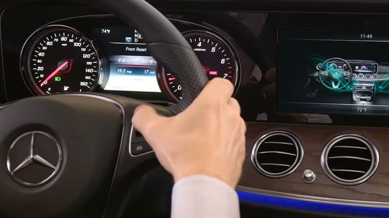 Mercedes-Benz steering wheel with hand controlling a button