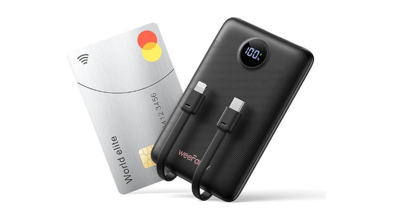 A black power bank with two cords next to an ATM card, they are the same size.