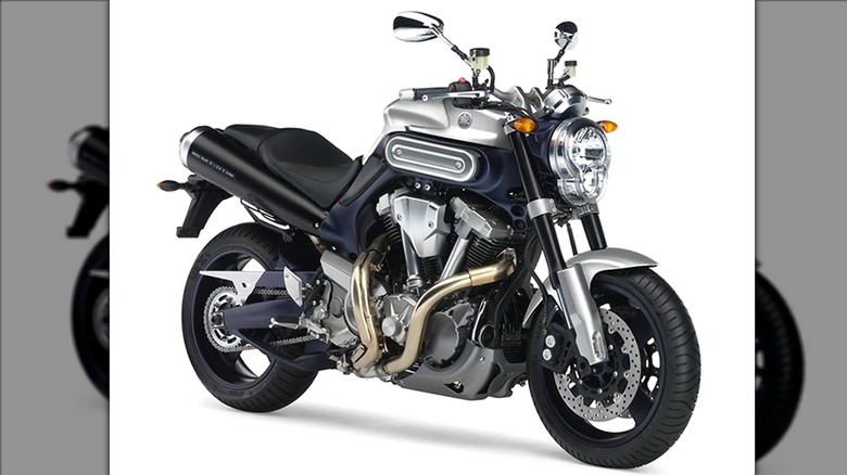 A 2005 powerful Yamaha MT-01 motorcycle sits in a studio setup, showing off its massive V-twin engine, dual exhausts, and muscular streetfighter stance.