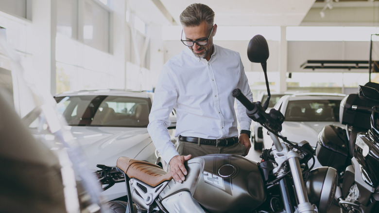 Man feeling the tank of a motorcycle
