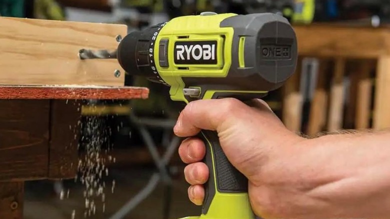 Person drilling hole with Ryobi drill
