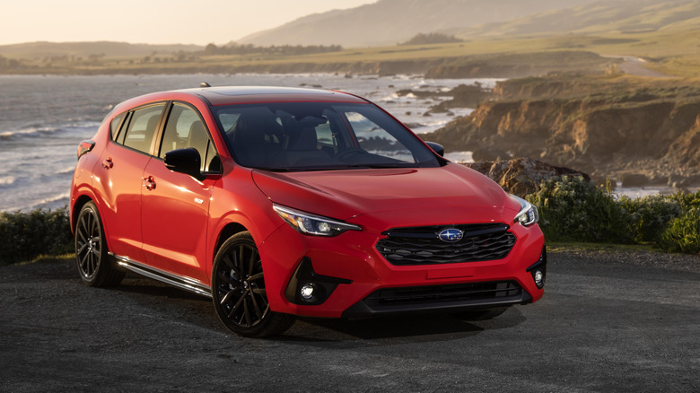 Red 2024 Subaru Impreza parked near ocean