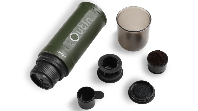 OutIn portable espresso machine with accessories laid out on a white surface