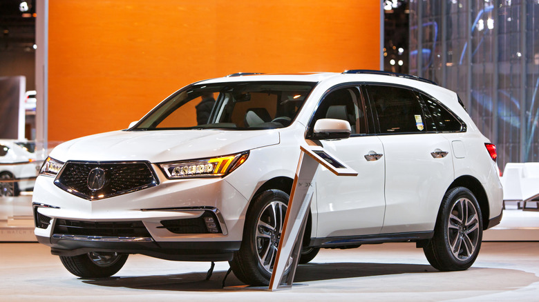 A white 2018 Acura MDX on display at an auto show.