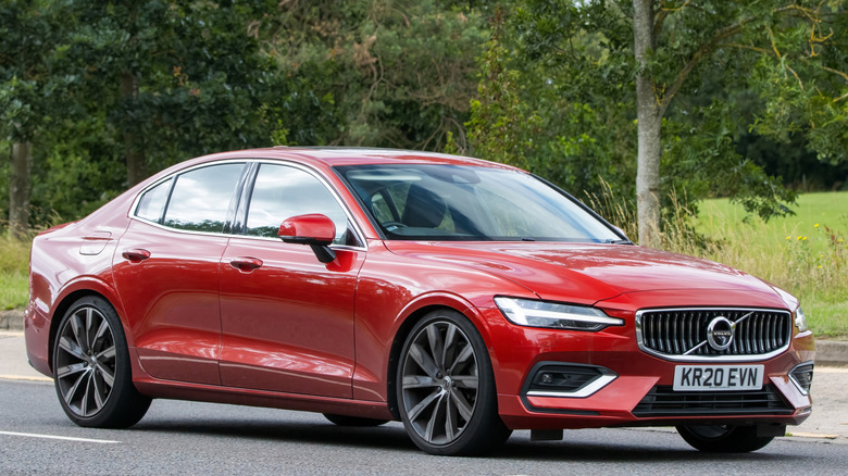 A red Volvo S60 parked on pavement.