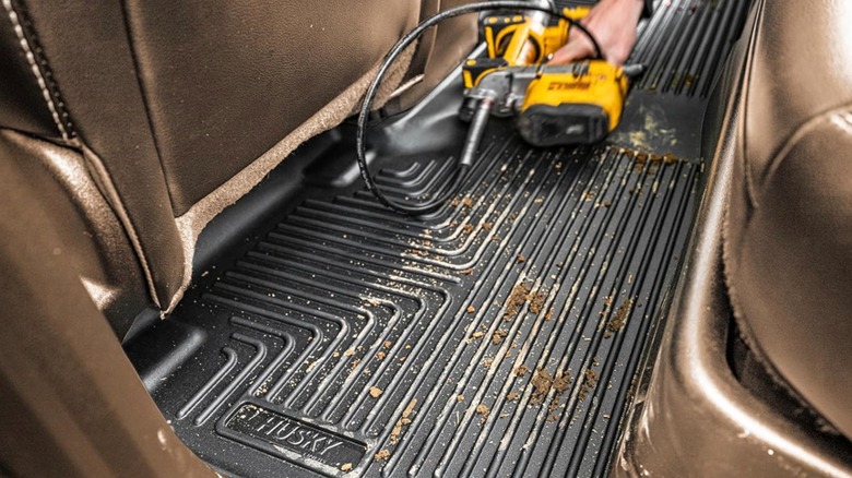 Black Husky Liner car mat filled with debris