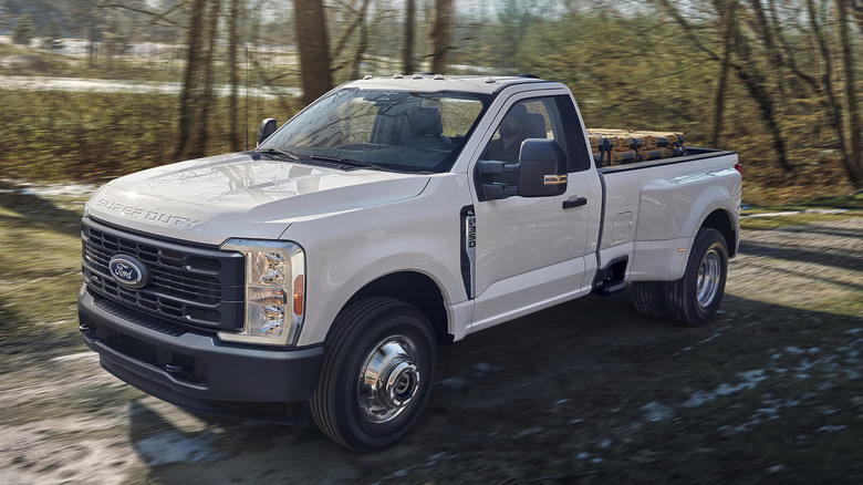 A white 2025 Ford F-350 Super Duty XL running on unpaved road