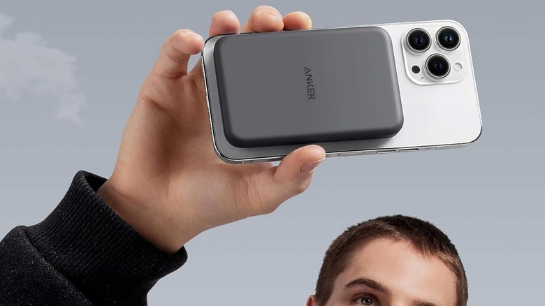 man holding powerbank attached to phone