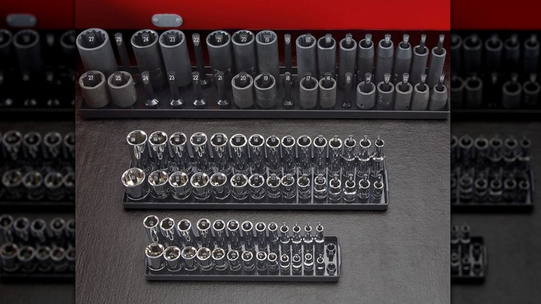 sets of silver and black sockets organized on trays