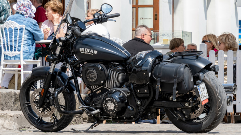 A black Indian Chief ark horse motorbike parked outside a cade