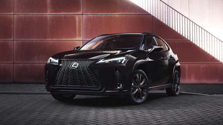 A black Lexus UX parked by a building