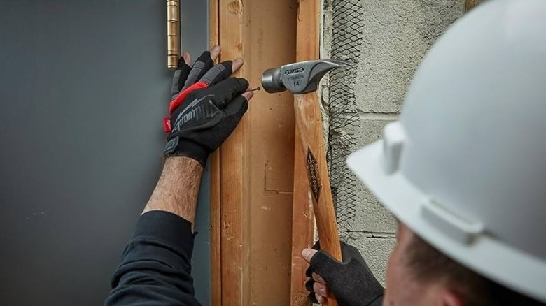 person hammering in Milwaukee fingerless gloves