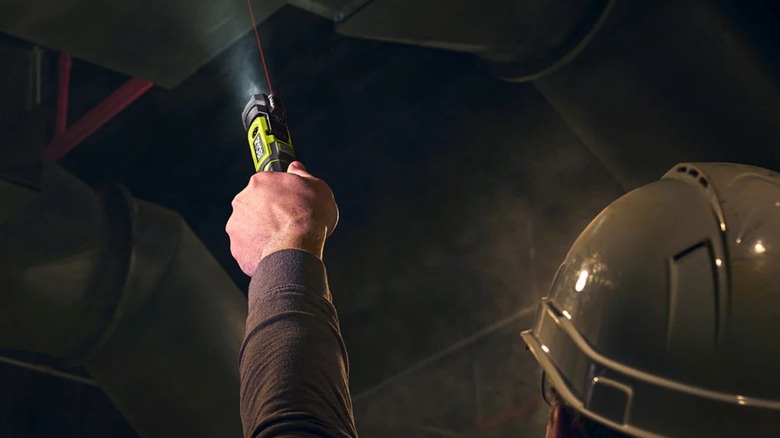 Person pointing Ryobi Ryobi USB Lithium LED Pivoting Flashlight and Laser upwards