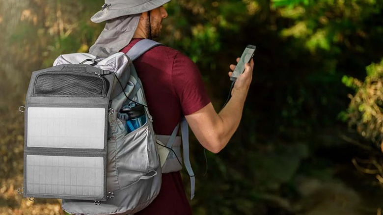 Backpacker wearing a Ryobi 14-watt Foldable Solar Panel on his back