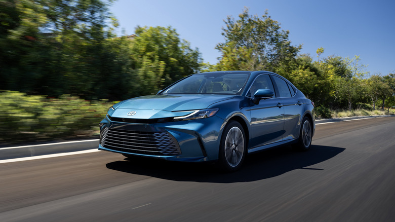 A three quarter frontal shot of a blue 2026 Toyota Camry driving