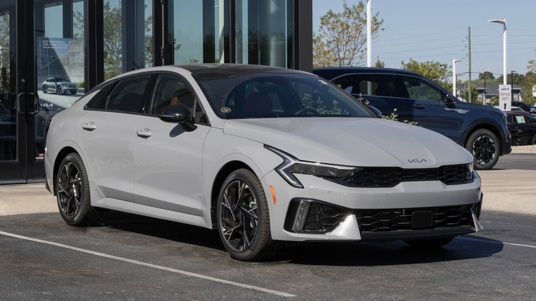 An angled photograph of the front and side of a gray 2025 Kia K5