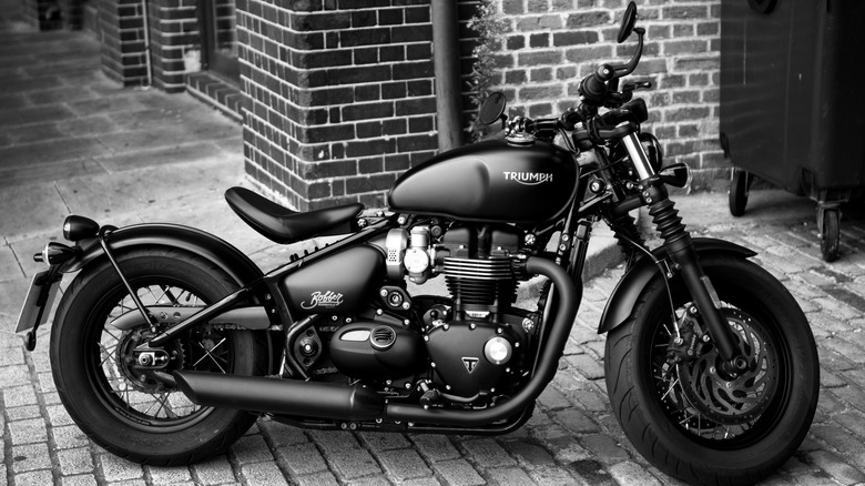 A grayscale shot of a parked Triumph Bonneville Bobber Motorcycle