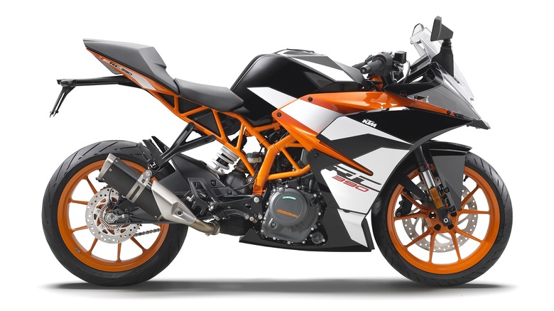 A sharp and track-ready KTM RC390 standing in profile, showing off its bright orange frame and wheels.