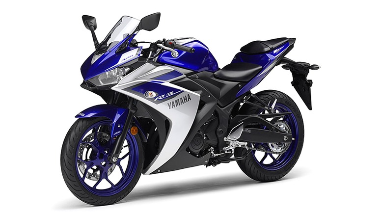 A Yamaha YZF-R3 shown from the side in its signature blue-and-white color scheme sitting poised like a mini superbike.