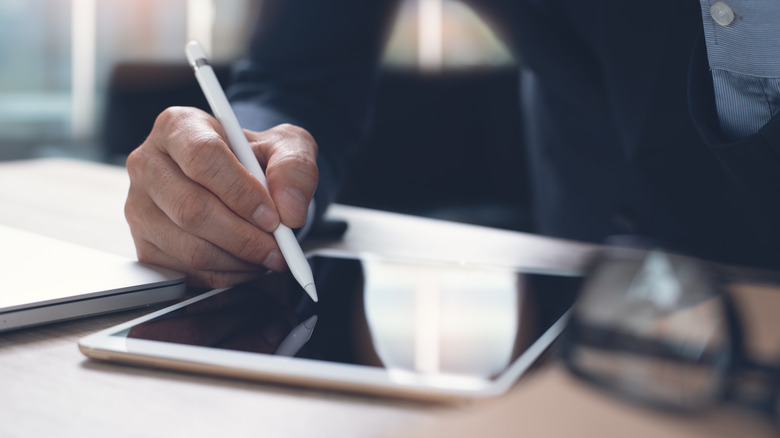 Person using a stylus with a tablet