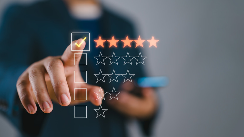 Finger pointing at a five star holographic image