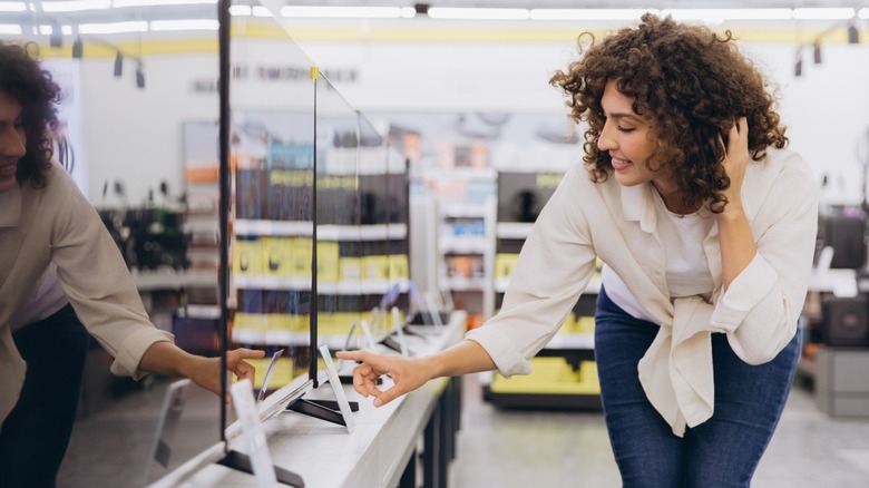 Person examining TV at electronics store