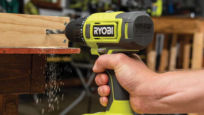 A man drilling into wood with a Ryobi power drill