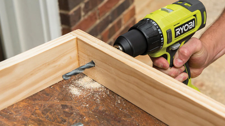 A Ryobi power drill drilling into a piece of wood