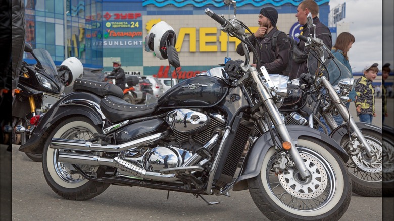 A black Suzuki C50 parked with other motorcycles.